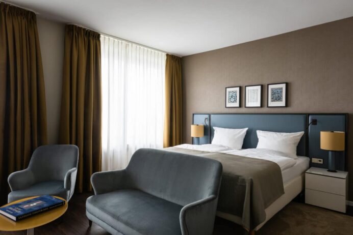 ameron koenigshof bonn juniorsuite bett couch sessel fenster credit althoff hotels